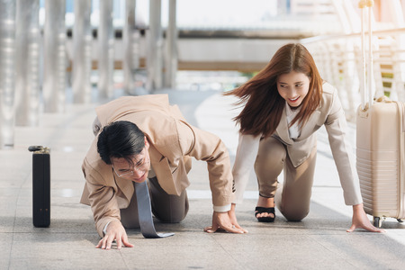 Male business man fall down while starting to run with business women, business competitionの写真素材