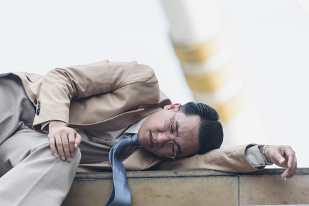 Exhausted and tired businessman and Lie on the stairs in the cityの写真素材