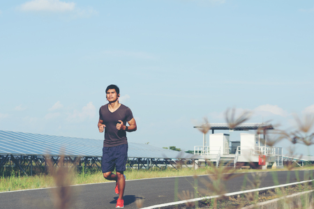 Men jogging in a solar power plantの写真素材