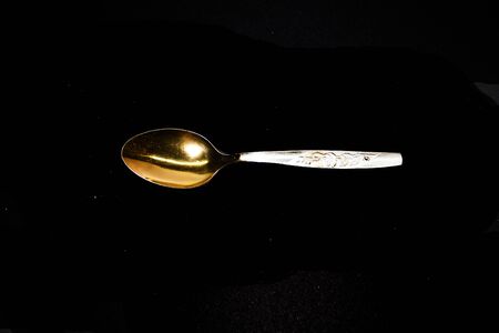 iron spoon isolated on black backgroundの写真素材