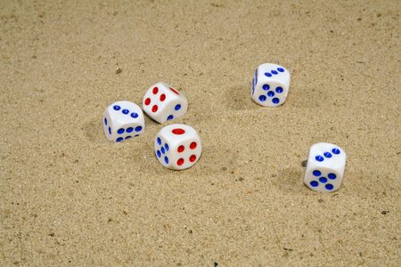 playing dice on yellow sandの写真素材