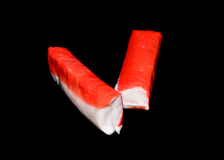 crab sticks isolated on black backgroundの写真素材