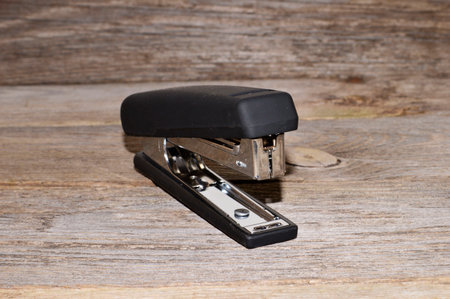 stapler isolated on wooden background - close-up
