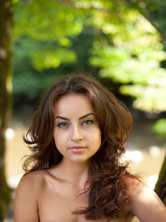 Portrait of a young woman on blured forest backgroundの写真素材
