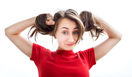 Young woman playing with her hair on white backgroundの写真素材