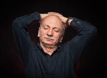 Portrait of an elderly man with hands behind head and closed eyesの写真素材
