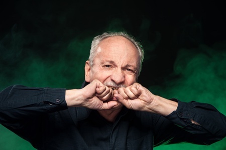 old man biting his hands  in despairの写真素材