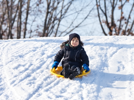 Boy on sleigh. Sledding at winter timeの写真素材