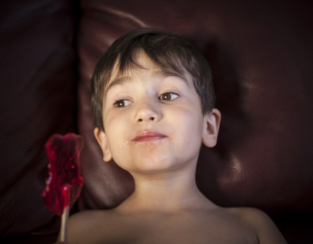 Close Up of Young Boy Eating A Lollipopの写真素材