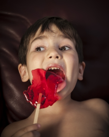 Close Up of Young Boy Eating A Lollipopの写真素材