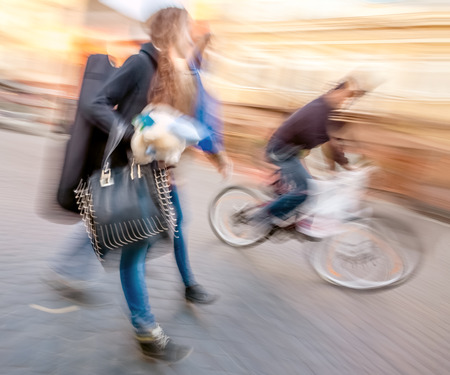 Young people and cyclist going about their business. Street scene with intentional motion blur.の写真素材