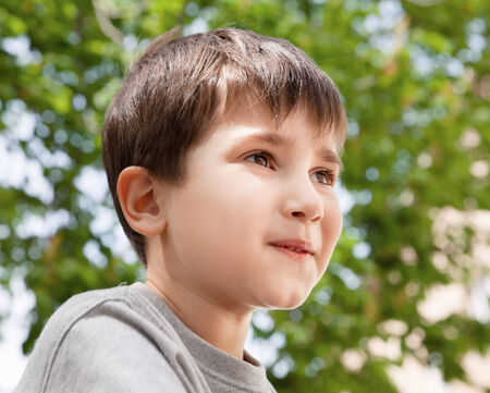 Happy little boy smiling on blurred backgroundの写真素材