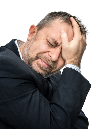 Headache. Portrait of an middle age man with face closed by hands. Isolated on white
の写真素材