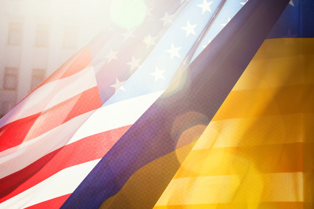 Ukrainian and American flags in the sunlight with lens flareの写真素材