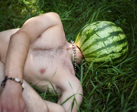 Humorous photo of a boy with a watermelon instead of headの写真素材