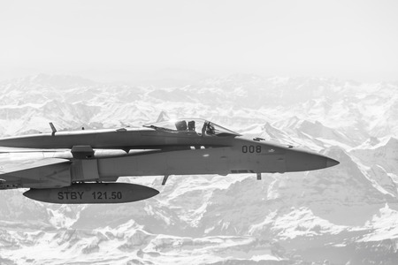 ALPS, SWITZERLAND - Apr 21, 2015: F-18 fighter jet of Swiss military air force on combat duty in the skies over Switzerland in the area of the Swiss Alpsのeditorial素材