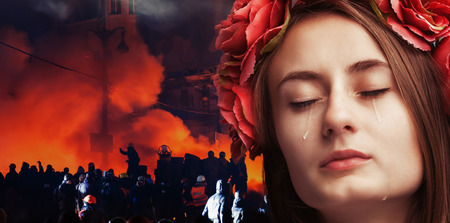 Patriotic concept Ukraine in fire. Close-up portrait of beautiful crying girl with tears on her...