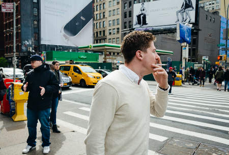 NEW YORK, USA - Apr 28, 2016: Manhattan street scene. The Americans on the streets of New York. Man with a cigaretteのeditorial素材