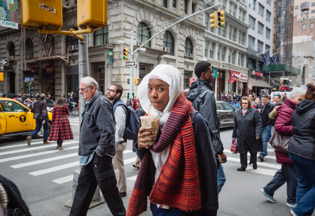 NEW YORK, USA - Apr 29, 2016: Manhattan street scene. New Yorkers and tourists walking on Manhattan...