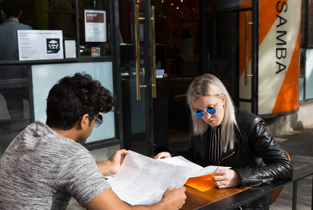 NEW YORK, USA - Apr 30, 2016: Young couple studying fast food restaurant menu on the streets of New York City. Manhattan street scene. The Americans on the streets of NYCのeditorial素材