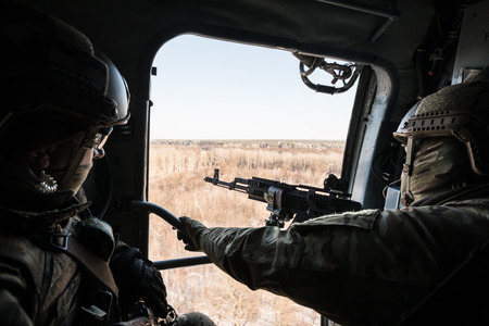 DONETSK REGION, UKRAINE - Dec 05, 2016: Soldiers of Armed Forces of Ukraine with guns on board of Ukrainian army helicopter during a combat mission in area of antiterrorist operation in Donetsk regionのeditorial素材