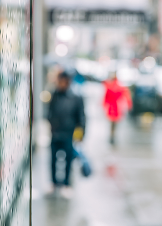 Rain in the city. Blurred scene of urban life. Emotional abstract background with defocused people on the streets of New York on a rainy dayの写真素材