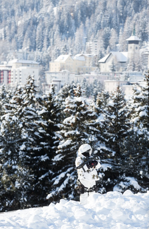 DAVOS, SWITZERLAND - Jan 17, 2017: Security in Davos. A police officer in a camouflage suit with a gun at the guard post of the World Economic Forum in Davosのeditorial素材