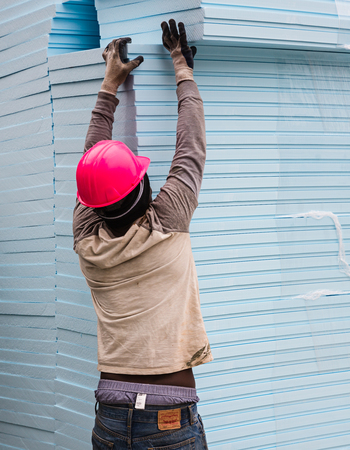 NEW YORK, USA - Apr 29, 2016: Worker on the construction site takes from stock the necessary amount of thermal insulation panelsのeditorial素材