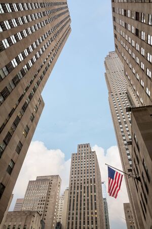 NEW YORK, USA - May 05, 2016: Buildings and skyscrapers of Manhattan. American flag on the streets of Manhattan, New York City.のeditorial素材