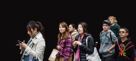 NEW YORK, USA - May 03, 2016: A group of young people of different nationalities, the boys and girls, go about their business against the black wall in Manhattan, NYCのeditorial素材