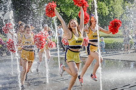 UZHGOROD, UKRAINE - May 28, 2017: Cheerleaders Team. Group of happy Cheerleaders enjoy jogging through the fountain after the performance on the student holidayのeditorial素材