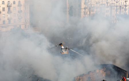 KIEV, UKRAINE - Jun 20, 2017: Ukrainian firefighters try to extinguish a fire in a three-story house on Khreshatyk street, the main street in Kiev. Firefighters in actionのeditorial素材