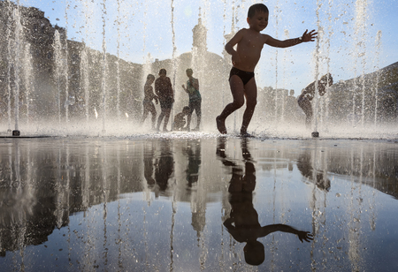 KIEV, UKRAINE - Jun 28, 2017: Happy children playing in a water fountain and enjoying the cool streams of water in a hot dayのeditorial素材