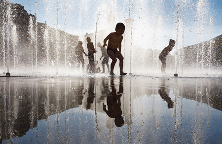 KIEV, UKRAINE - Jun 28, 2017: Happy children playing in a water fountain and enjoying the cool streams of water in a hot dayのeditorial素材