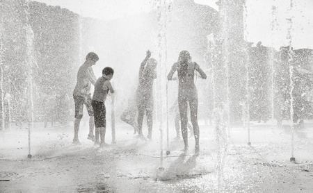 KIEV, UKRAINE - Jun 28, 2017: Happy children playing in a water fountain and enjoying the cool streams of water in a hot dayのeditorial素材