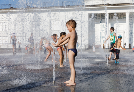 KIEV, UKRAINE - Jun 28, 2017: Happy children playing in a water fountain and enjoying the cool streams of water in a hot dayのeditorial素材