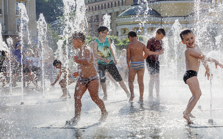 KIEV, UKRAINE - Jun 28, 2017: Happy children playing in a water fountain and enjoying the cool streams of water in a hot dayのeditorial素材