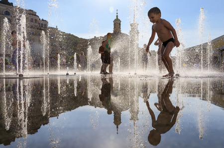 KIEV, UKRAINE - Jun 28, 2017: Happy children playing in a water fountain and enjoying the cool streams of water in a hot dayのeditorial素材