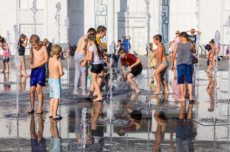 KIEV, UKRAINE - Jun 28, 2017: Happy children playing in a water fountain and enjoying the cool streams of water in a hot dayのeditorial素材