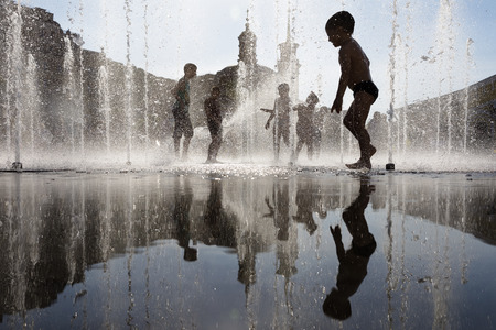 KIEV, UKRAINE - Jun 28, 2017: Happy children playing in a water fountain and enjoying the cool streams of water in a hot dayのeditorial素材