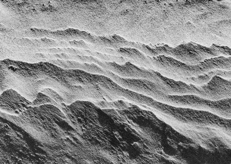 Ripples in wet sand background texture. Beach sand background