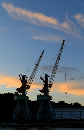 LIEPAJA, LATVIA - JUN 25, 2017: Liepajas beautiful evening at sunset. Silhouettes of port cranesのeditorial素材