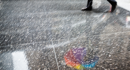 Rain in New York City. Reflections from wet tile slabs. Pedestrians hurry on their business. Motion blur imageの写真素材