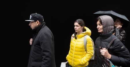 NEW YORK, USA - May 03, 2016: A group of young people of different nationalities, the boys and girls, go about their business against the black wall in Manhattan, NYCのeditorial素材