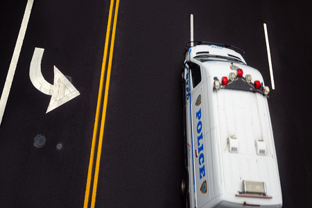 NEW YORK, USA - May 03, 2016: Road markings on asphalt on the street of Manhattan in New York City. Motion blured police car moves along the road with a high speed.のeditorial素材