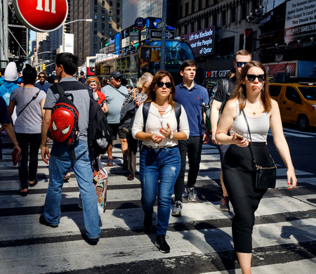 NEW YORK, USA - Sep 23, 2017: Manhattan street scene. New Yorkers and tourists in a hurry about their business, walking and relaxing on Times Square in NYC. Group of people on a pedestrian crossingのeditorial素材
