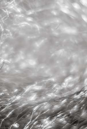 Abstract blurred background. Beautiful lines and light spots of blurred metal net with defocused bokehの写真素材