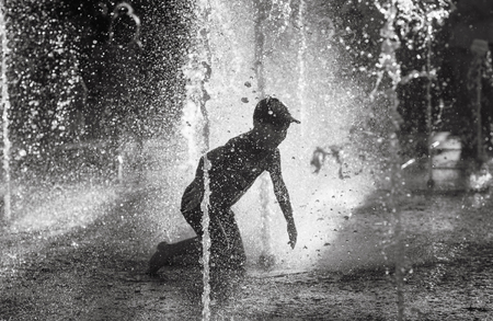 KIEV, UKRAINE - Jun 05, 2018: Cheerful and happy children playing in a water fountain and enjoying the cool streams of water in a hot day. Hot summer.のeditorial素材