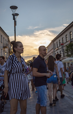 Lublin, Poland - Jul 27, 2018: Crowds of tourists and holidaymakers on the streets of the old city of Lublin. Young man and pregnant girl. Lublin is the ninth largest city in Polandのeditorial素材
