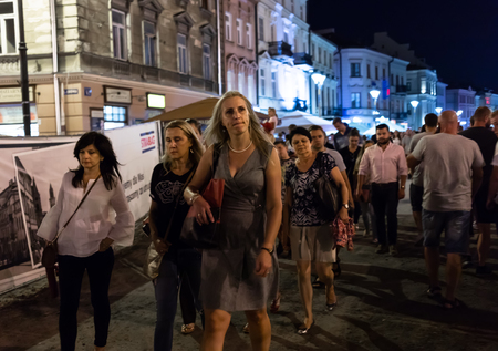 Lublin, Poland - Jul 27, 2018: Crowds of tourists and holidaymakers on the streets of the old city of Lublin. Group of people are walking at late night. Lublin is the ninth largest city in Polandのeditorial素材